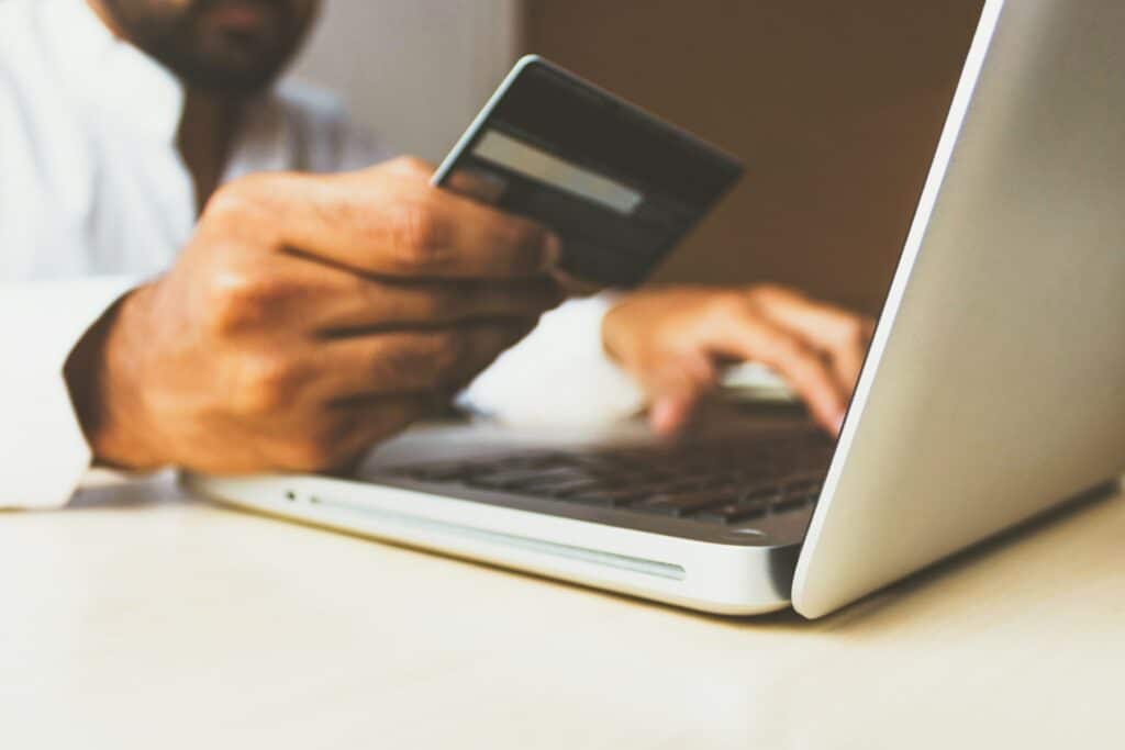 Man with credit card ready to make a purchase on laptop